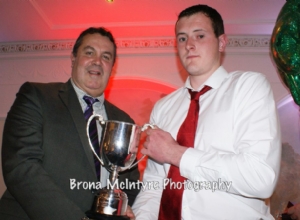 Ronan Gillan, the captain of the Reserve team receiving the Reserve Championship from Jim Murray