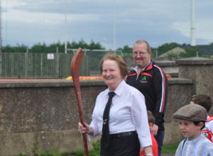 LOU MCKINLEY PAST CAMOGIE PLAYER LEADING THE PAGEANT IN OLD TIME CAMOGIE GEAR INCLUDING OLD HURL